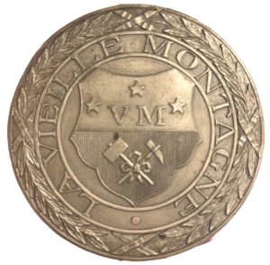 Armoiries de l'entreprise entouré d'une couronne végétale.