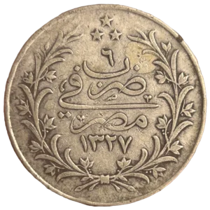 inscriptions en langue arabe dans une couronne végétale.

١٣٢٧-٢