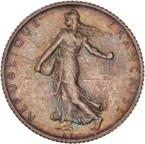 La France sous les traits d'une Semeuse marchant à gauche et semant à contre-vent. Derrière le soleil levant.