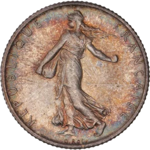 La France sous les traits d'une Semeuse marchant à gauche et semant à contre-vent. Derrière le soleil levant.