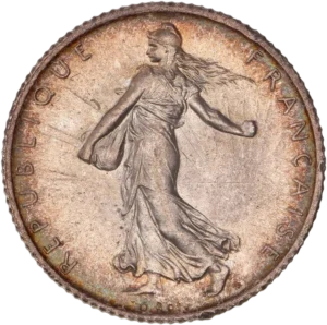 La France sous les traits d'une Semeuse marchant à gauche et semant à contre-vent. Derrière le soleil levant.