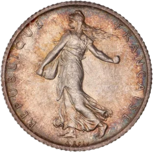 La France sous les traits d'une Semeuse marchant à gauche et semant à contre-vent. Derrière le soleil levant.