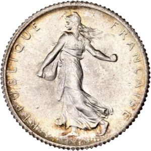 La France sous les traits d'une Semeuse marchant à gauche et semant à contre-vent. Derrière le soleil levant.