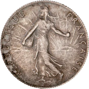 La France sous les traits d'une Semeuse marchant à gauche et semant à contre-vent. Derrière le soleil levant.