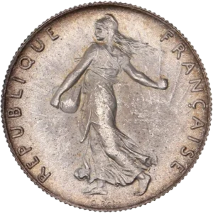 La France sous les traits d'une Semeuse marchant à gauche et semant à contre-vent. Derrière le soleil levant.