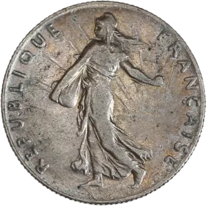 La France sous les traits d'une Semeuse marchant à gauche et semant à contre-vent. Derrière le soleil levant.