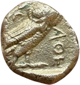 Chouette debout à droite, la tête de face ; derrière, une branche d'olivier et un croissant.