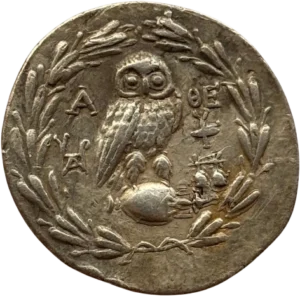 Tête d'Athéna à droite, coiffée du casque attique à cimier, avec collier et boucles d'oreilles.