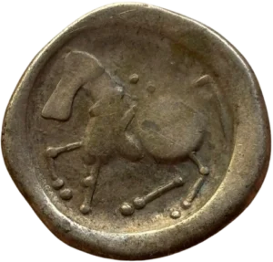 Restes de la tête laurée de Zeus à droite, fortement stylisée.