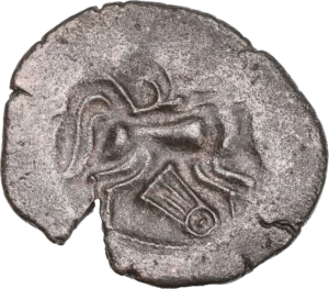 Tête humaine à droite, chevelure en trois rouleaux et divisés en grosses mèches en forme d’S.