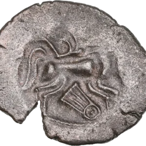 Tête humaine à droite, chevelure en trois rouleaux et divisés en grosses mèches en forme d’S.