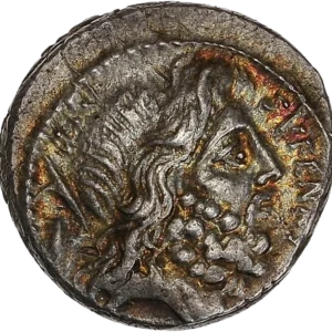 Tête barbue de Saturne à droite ; derrière, tête de harpon et pierre conique.