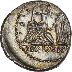 Rome assise à gauche sur un monceau d'armes, tenant une haste, couronnée par la Victoire debout derrière elle, tenant une couronne et une palme.