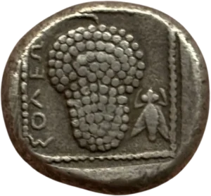 Une Amazone coiffée d’un bonnet pointu à demi-nu, agenouillée, tenant son arc des deux mains, son carquois sur le côté. Dans son dos, une petite tête de Satyre de face.