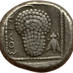 Une Amazone coiffée d’un bonnet pointu à demi-nu, agenouillée, tenant son arc des deux mains, son carquois sur le côté. Dans son dos, une petite tête de Satyre de face.