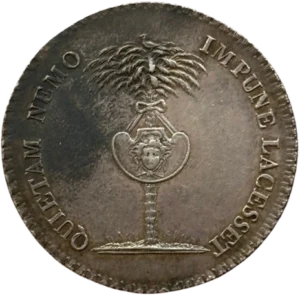 Un bouclier avec tête de Méduse attaché à un palmier.