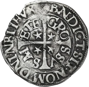 Croix accostée de 4 étoiles et entourée de deux rangées de légendes.