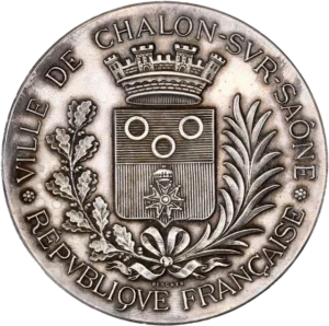 Blason de ville couronné et entouré d'une couronne végétale.